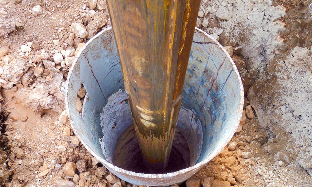 A bucket of water is pouring into the ground.