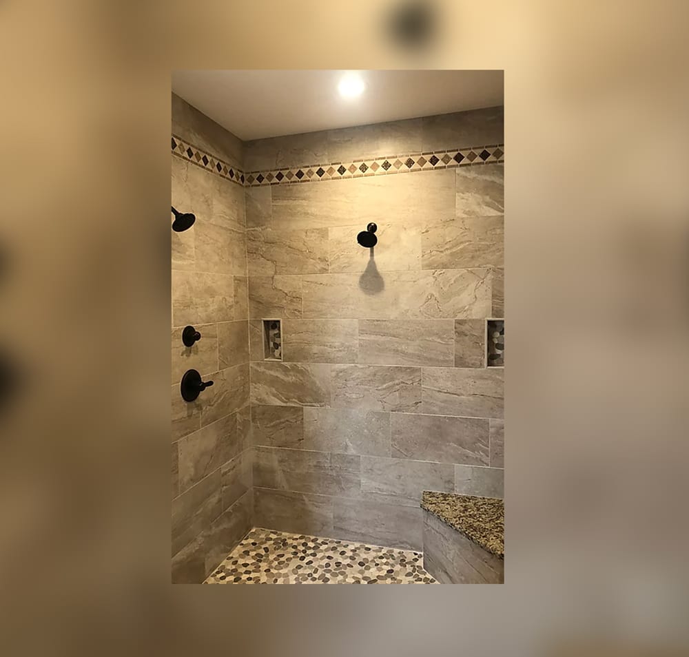 A bathroom with a shower and tiled walls.